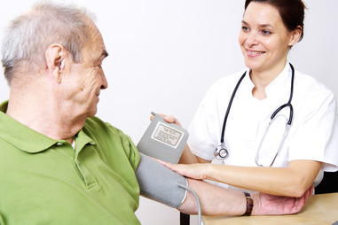 A7TA1P Female nurse checking man's blood pressure